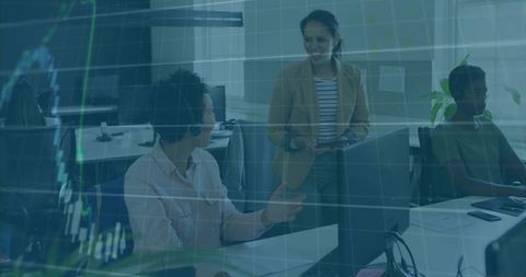 Women collaborating at workstations reviewing financial charts overlay in open-plan office