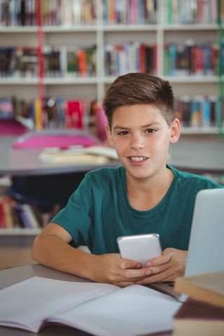 Student Using Smartphone in Modern Library Learning Environment