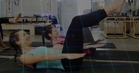 Women Exercising at Pilates Studio with Reformer Equipment