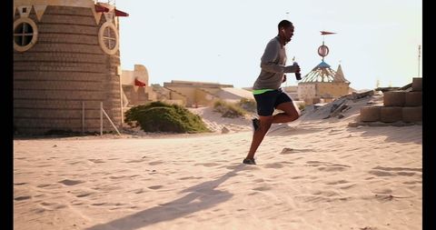 Athletic Runner Jogging on Sunny Beach with Water Bottle