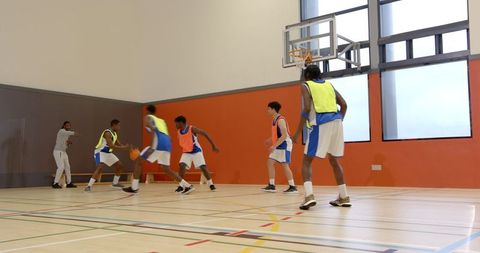 Basketball Training with Coach Guiding Young Athletes in Gym