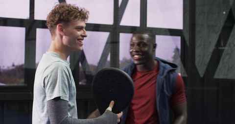 Diverse Male Friends Enjoying Padel Game in Modern Court