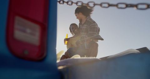 Couple enjoying summer together with drinks on car