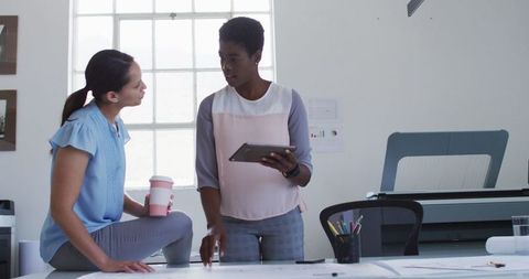 Two professional businesswomen collaborating in modern office