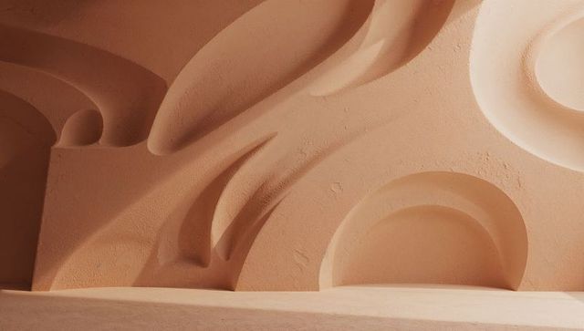 Minimalist sculptural plaster wall with recessed niches and soft light casting shadows