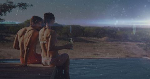 Romantic Couple Relaxing by Infinity Pool at Sunset