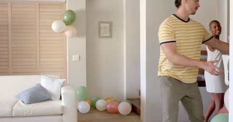 Couple Preparing Home for Festive Celebration with Decorations