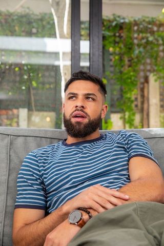 Relaxed man lounging on gray sofa in tranquil modern living room