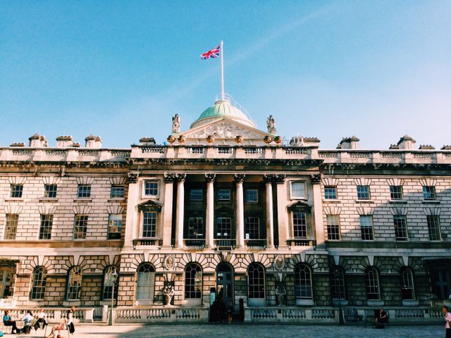 Iconic Historical Building with British Flag Against Clear Blue Sky - Download Free Stock Images Pikwizard.com