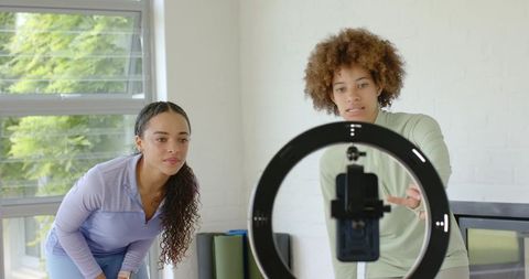African american women recording workout tutorial with ring light and smartphone in studio