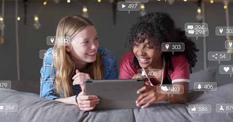 Diverse girlfriends engaging with social media on tablet