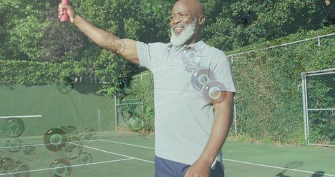 Senior man exercising with dumbbells on tennis court promoting fitness