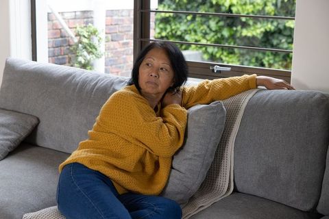 Senior woman relaxing on sofa in modern home interior