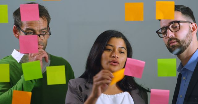 Team brainstorming using colorful sticky notes on glass wall - Download Free Stock Images Pikwizard.com