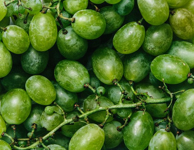 Close-up of a cluster of fresh, juicy green grapes. Great for illustrating concepts related to healthy eating, organic produce, vegetarian diet, and fresh produce. Ideal for use in food blogs, nutrition articles, grocery store advertisements, or healthy lifestyle promotions.