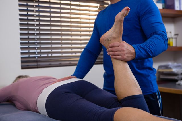 Physiotherapist treating a patient with a leg massage in a clinical setting. Useful for illustrating healthcare services, physical therapy practices, rehabilitation processes, and wellness treatments. Ideal for medical websites, physiotherapy promotional materials, and health-related articles.
