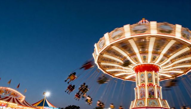 Spinning vintage swing carousel at dusk showing motion blur and carnival lights