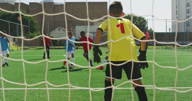 Kids Playing Soccer On Sunny Field With Goalkeeper - Download Free Stock Images Pikwizard.com