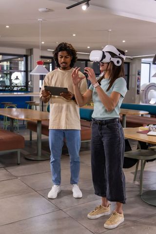 Diverse friends testing vr headset in modern coworking cafe, collaborating on virtual demo