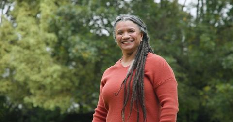 Elderly Woman Embracing Nature with Joyful Smile in Garden