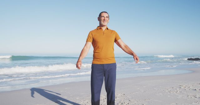 This image shows a mature man enjoying a calm and peaceful morning by the beach. It can be used for promoting travel destinations, relaxation, wellness, vacation packages, and lifestyle content emphasizing tranquility and nature.