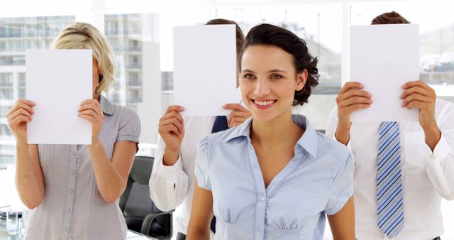 Confident Woman Standing Out in Office While Colleagues Cover Faces - Download Free Stock Images Pikwizard.com