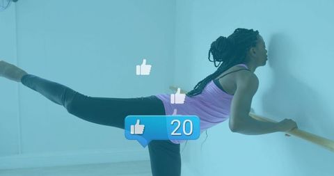 Woman practicing barre in pale studio with social media like icons showing 20 likes