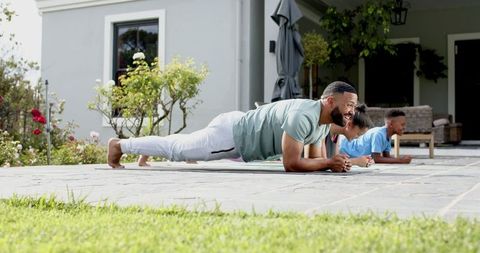 Family fitness outdoors with father and children exercising