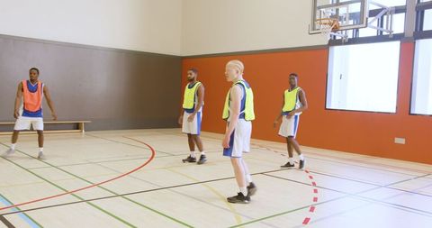 Diverse Male Basketball Teammates Preparing for Game in Gym