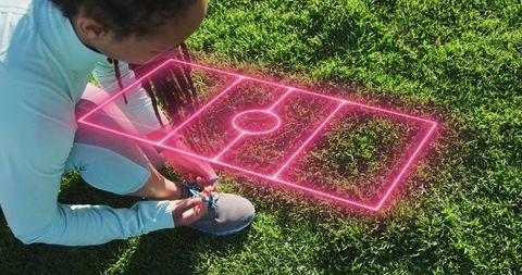Athlete Tying Shoelaces with Neon Soccer Field Representation