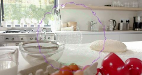 Sunlit kitchen with dough resting on floured countertop, bowls, eggs and digital overlay