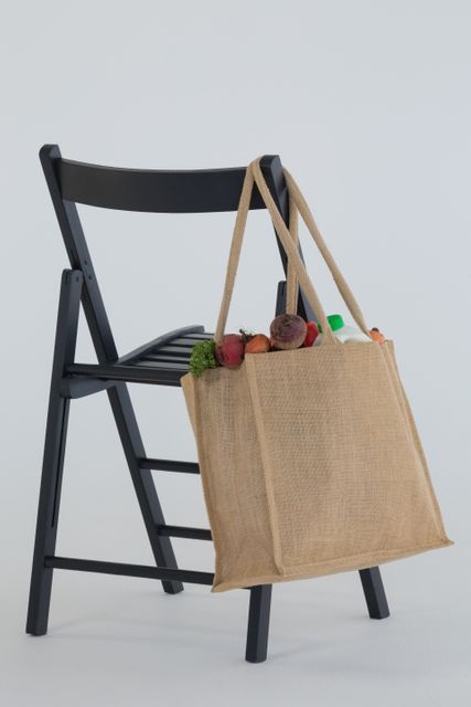 Close-up of fresh vegetables bag hanging on black chair