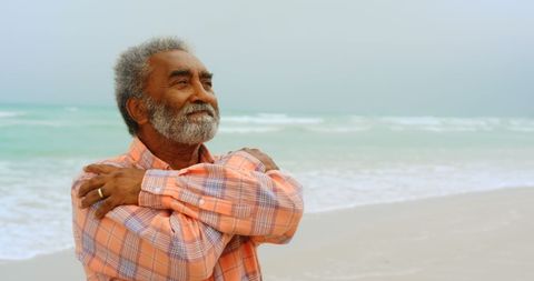 Elderly man in plaid shirt enjoys breezy beach