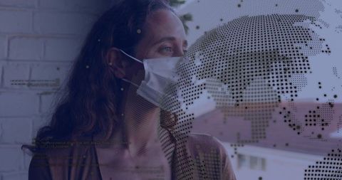 Adult female wearing medical mask standing at window gazing with digital world map overlay
