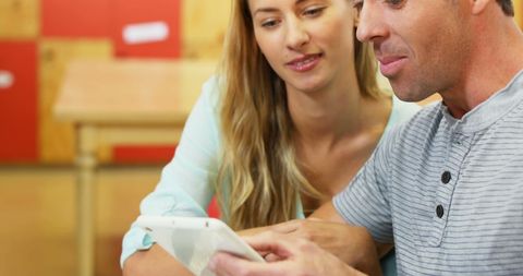 Middle-Aged Couple Discussing Content on Tablet device Together