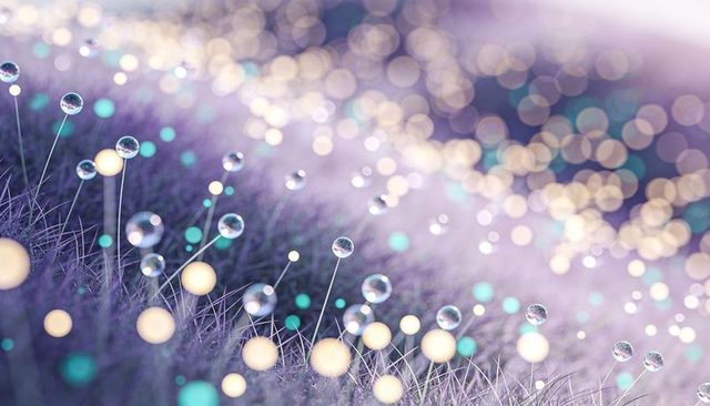 Lavender bokeh dewdrops on grass with glowing orbs and glasslike droplets, pastel macro