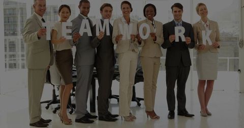 Corporate Team Holding TEAMWORK Letters in Bright Office, Collaboration Focus for Business