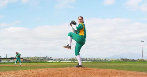 Female softball athlete pitching during outdoor game