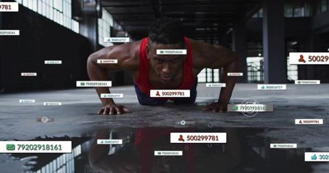 Intense male athlete doing push-up with ar performance overlays in industrial warehouse gym reflecti