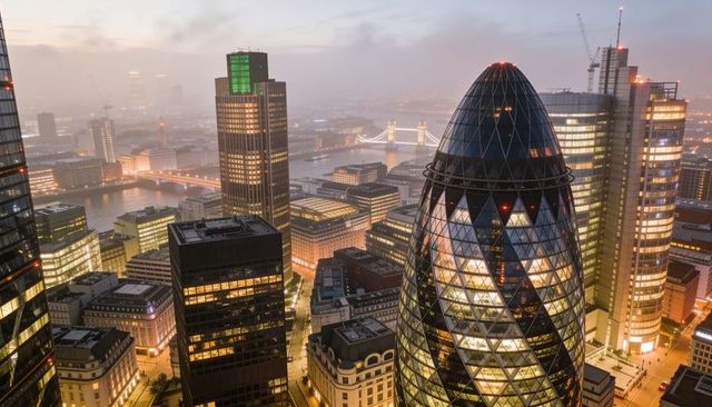 Gherkin and river thames skyline at dusk glowing with tower bridge lights and glass towers