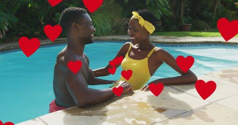 Happy Couple in Swimming Pool Surrounded by Love Hearts