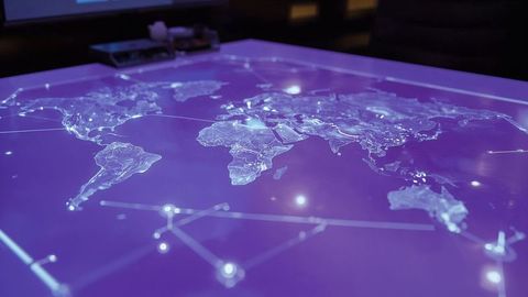Futuristic Touchscreen Table Displaying Digital World Map