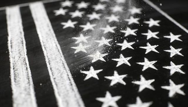 Creating powdered American flag with stars and stripes on dark textured surface