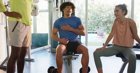Group Fitness Session with People Relaxing by Weights Bench