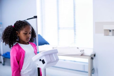 Young Child Standing Next to Height Rod in Pediatric Clinic