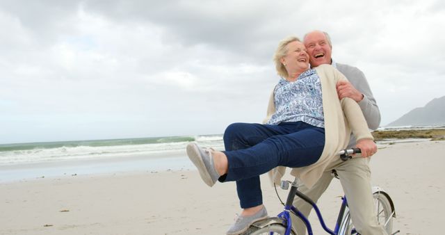 Happy Elderly Couple Laughing on Beach Bicycle Ride - Download Free Stock Images Pikwizard.com