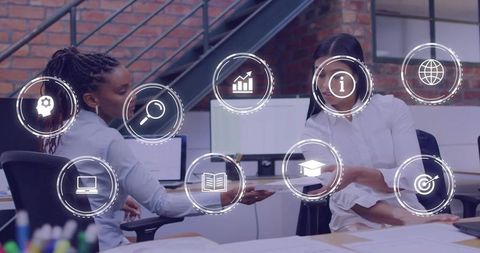 Colleagues exchanging tablet with AR business icons in modern office
