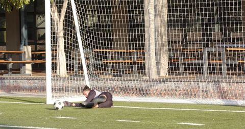 Goalkeeper Diving to Save Soccer Ball