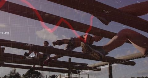 Athletes straddling wooden beams climbing obstacle course with red performance graph