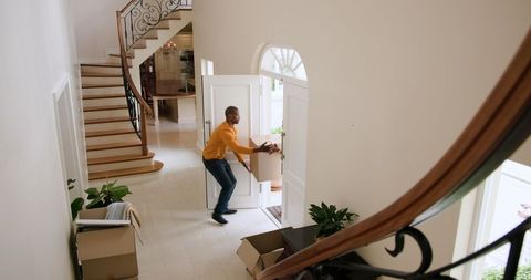 Couple moving boxes into home, planning move